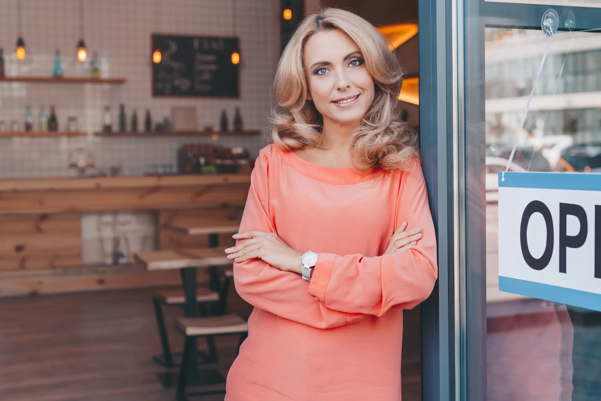 Small business owner standing in the open doorway of her shop